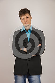 stylish young guy in jeans, a blue shirt and a black jacket