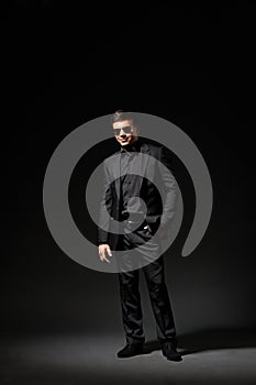 Stylish young man in black suit and sunglasses