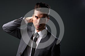 Stylish young man in business suit with hand in hair