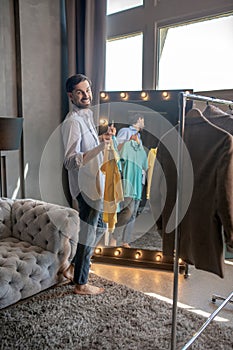 Stylish young man choosing clothes for today.