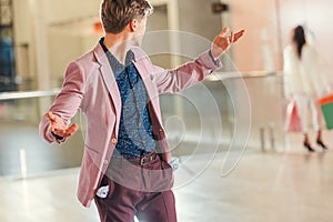 stylish young man with empty pockets turning back on girlfriend