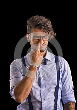 Stylish young man with a finger in his nose