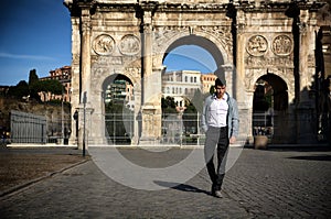 Stylish young man in front of Arco di Costantino, Rome, Italy photo