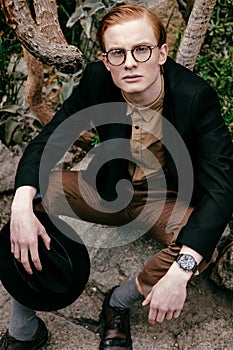 stylish young man with hat in eyeglasses looking