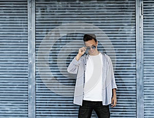 Stylish young man standing by the wall