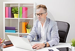 Stylish young man working with computer in office