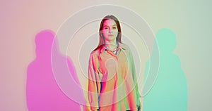 Stylish young teen girl moving in colourful neon studio light. Contemporary confident fashion female model. Copy space