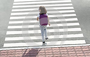 Stylish young teen girl walking with backpack. Active child. Kid runs across the crosswalk. Way forward. Direction to success.