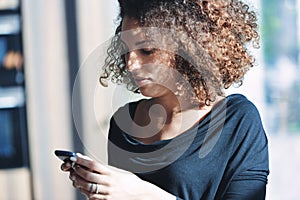 Stylish young woman checking her mobile phone for messages