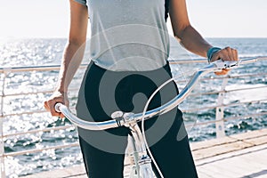 Stylish young woman holding the handlebar of her shiny vintage b