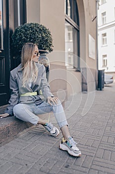 Stylish young woman posing in the street, wearing sunglasses photo