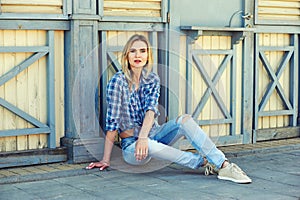 Stylish young woman in town . Girl dressed in jeans and a shirt