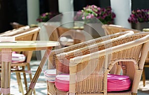 Stylishly decorated table in the restaurant with pink cushions on the chairs against t