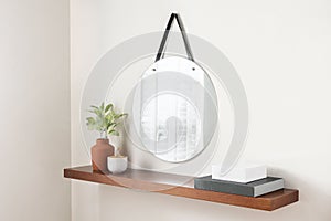 Stylishly designed wooden shelf presented with a decorative mirror propped up against it