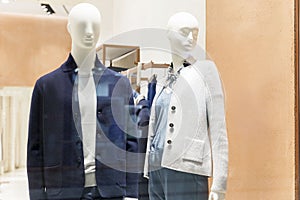 Stylishly dressed male and female mannequins in a clothing store window. New autumn-winter collection