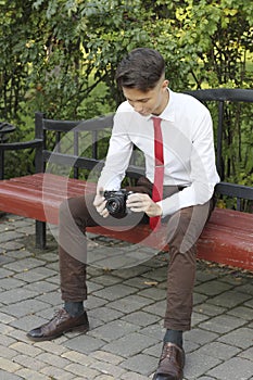 Stylishly dressed young man posing in a park. Retro style photo shoot.