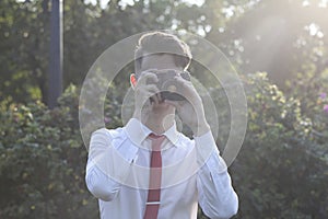 Stylishly dressed young man posing in a park. Retro style photo shoot.