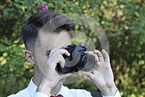 Stylishly dressed young man posing in a park. Retro style photo shoot.