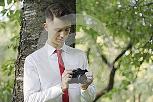 Stylishly dressed young man posing in a park. Retro style photo shoot.