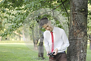 Stylishly dressed young man posing in a park. Retro style photo shoot.