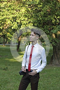 Stylishly dressed young man posing in a park. Retro style photo shoot.