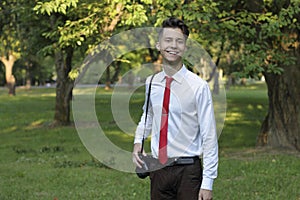 Stylishly dressed young man posing in a park. Retro style photo shoot.