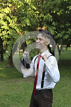 Stylishly dressed young man posing in a park. Retro style photo shoot.