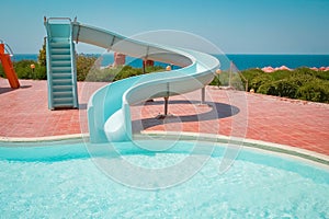 Stylishly interesting water slide in the pool near the sea on nature background