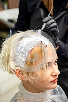 Stylist applies white dye to hair
