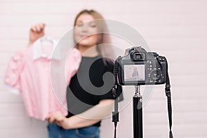 .A stylist blogger holds a blouse in front of the camera