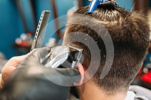 Stylist cut male head with trimmer closeup