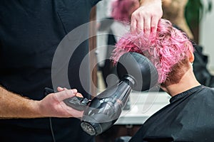 Stylist is drying woman hair
