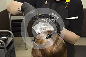 Stylist hairdresser combs hair with the help of special accessories for coloring and foil 04.12.2021 Russia, Irkutsk