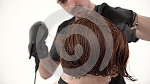 Stylist Hairdresser Makes a Stylish Hairstyle Young Guy with Red Hair.