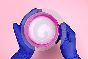 Stylist holds hair dye in his hands, color in a bowl