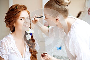 Stylist makes makeup bride before the wedding