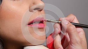Stylist painting the lips with a lip brush