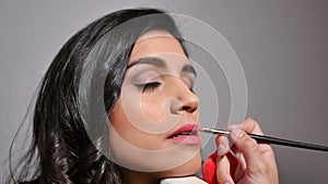 Stylist painting the lips with a lip brush