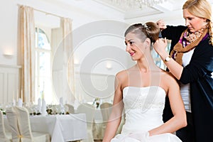 Stylist pinning up a bride's hairstyle