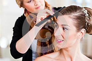 Stylist pinning up a bride's hairstyle