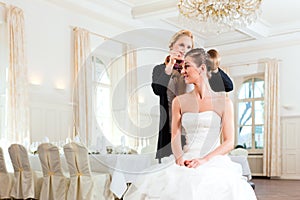 Stylist pinning up a bride's hairstyle