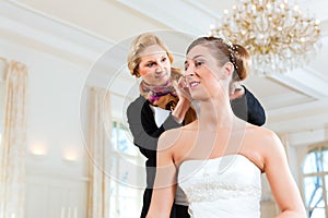 Stylist pinning up a bride's hairstyle photo
