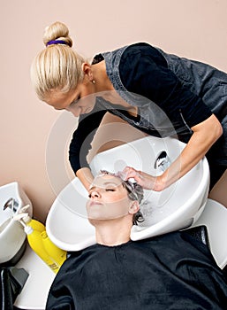 Stylist washing woman hair