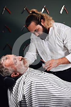 Stylist wetting beard before shaving it