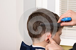 Stylist wetting the hair of a boy to make a hairdo