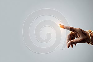 Stylized Hand Placing Sindoor on Parting Against a Light Backdrop in a Traditional Ceremony photo