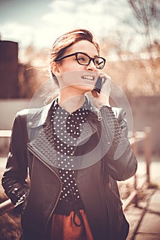 Stylized instagram colorized vintage fashion portrait of a young woman wearing glasses with beauty bokeh and small depth of f