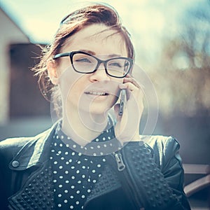 Stylized instagram colorized vintage fashion portrait of a young woman wearing glasses with beauty bokeh and small depth of f