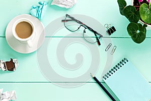 Stylized photo. Minimal flatlay composition with notebook and a house plant turquoise wooden table. Feminine workspace