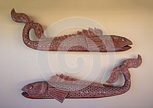 Stylized sculptures of two Koi fish on an outside wall in a resort on the Big Island, Hawaii.